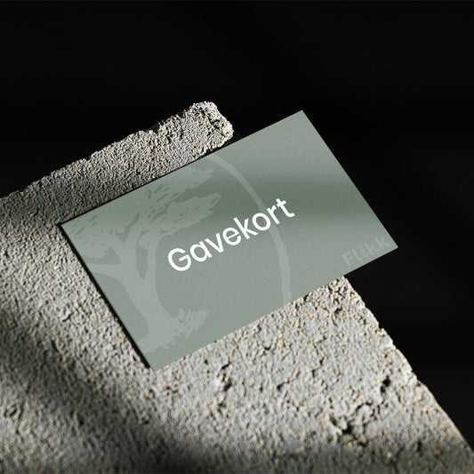 Et grønt gavekort fra Flåkk som ligger på en betongflate